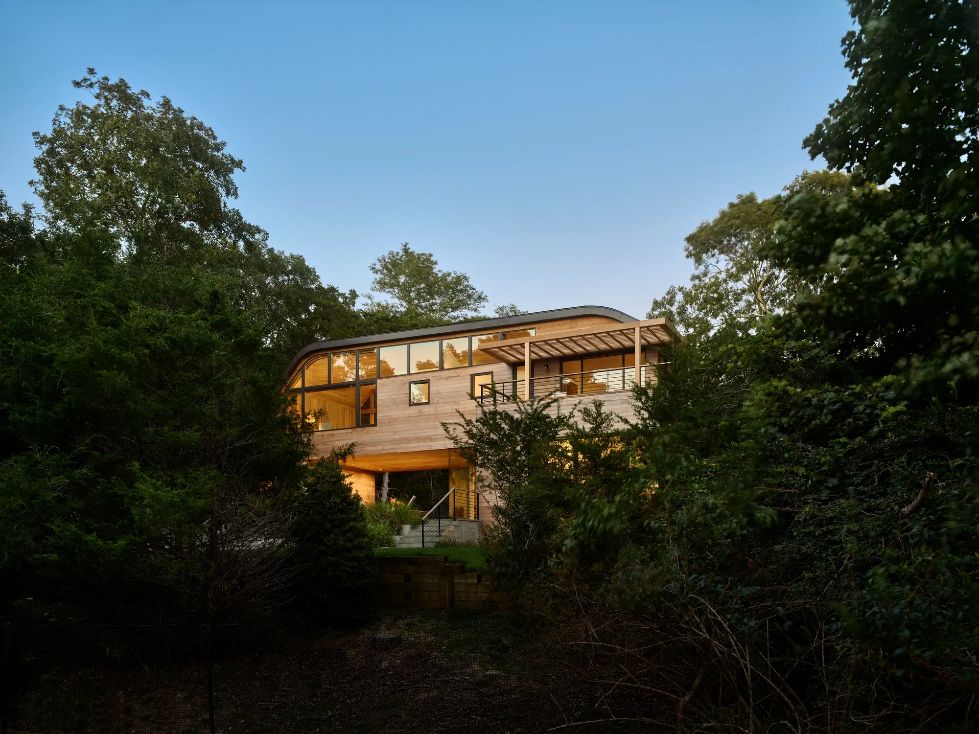 Hamptons home exterior surrounded by trees